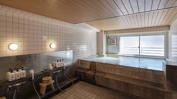 Relax in a spacious bathroom with a large bathtub and glass enclosure offering a view of the outside.