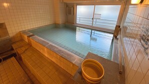 Una pequeña piscina interior con paredes de azulejos y una ventana.
