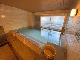 Una pequeña piscina interior con paredes de azulejos y una ventana.