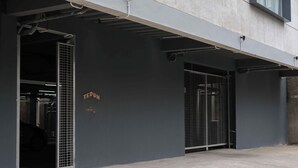 Einfahrt zu einer Parkgarage mit Metalltoren und einer Betonmauer.