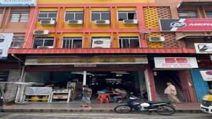 A multi-story building with several commercial establishments on the ground floor. - Hotel O 59 (Sibu)