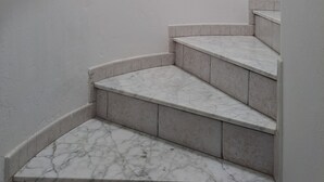 A staircase with marble steps and a metal handrail. - La Marea Casa en Arrieta, Tranquila. Cerca de Restaurantes y Playas de Arena (CN)
