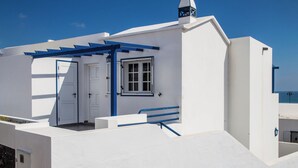 A white building with a blue door, a window, and a blue railing. - La Marea Casa en Arrieta, Tranquila. Cerca de Restaurantes y Playas de Arena (CN)
