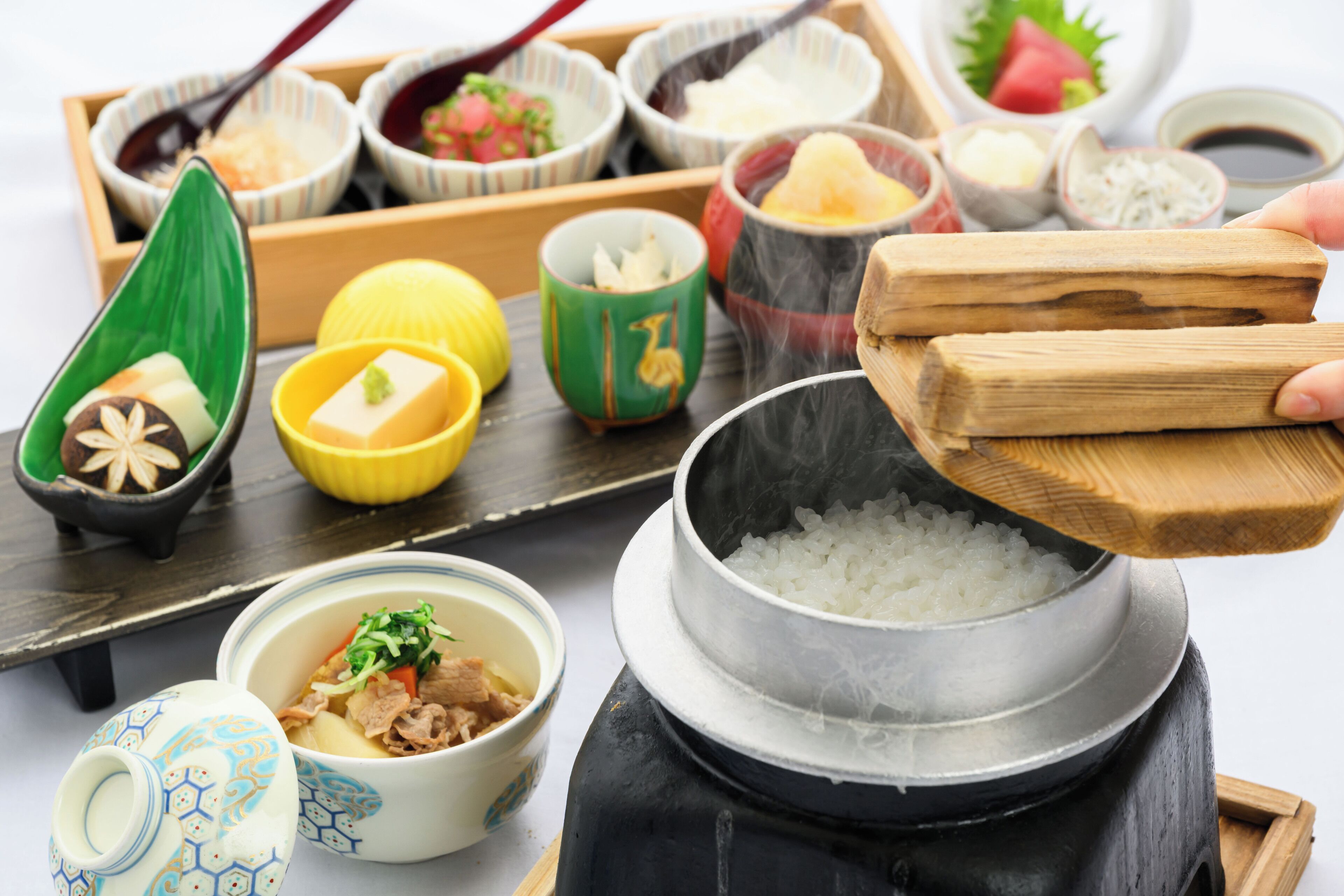 Una presentación tradicional de comida japonesa con diversos platos y utensilios.