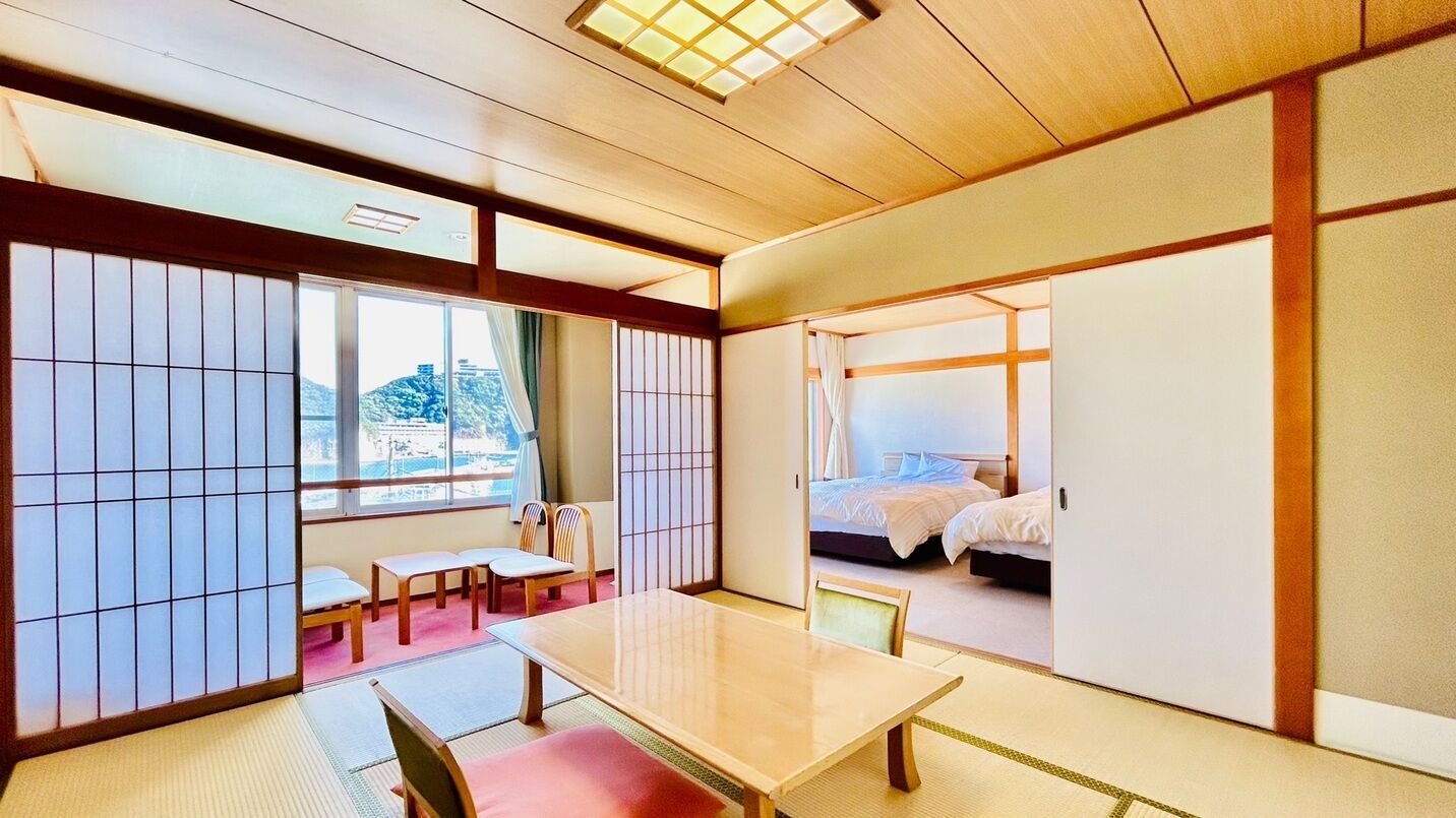 A traditional Japanese room with tatami flooring, a low table, and sliding doors.