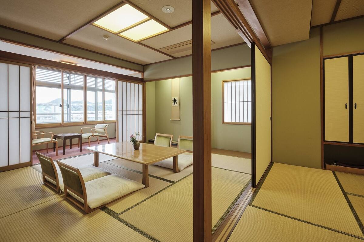 A traditional Japanese room with tatami flooring, a low table, and sliding doors.