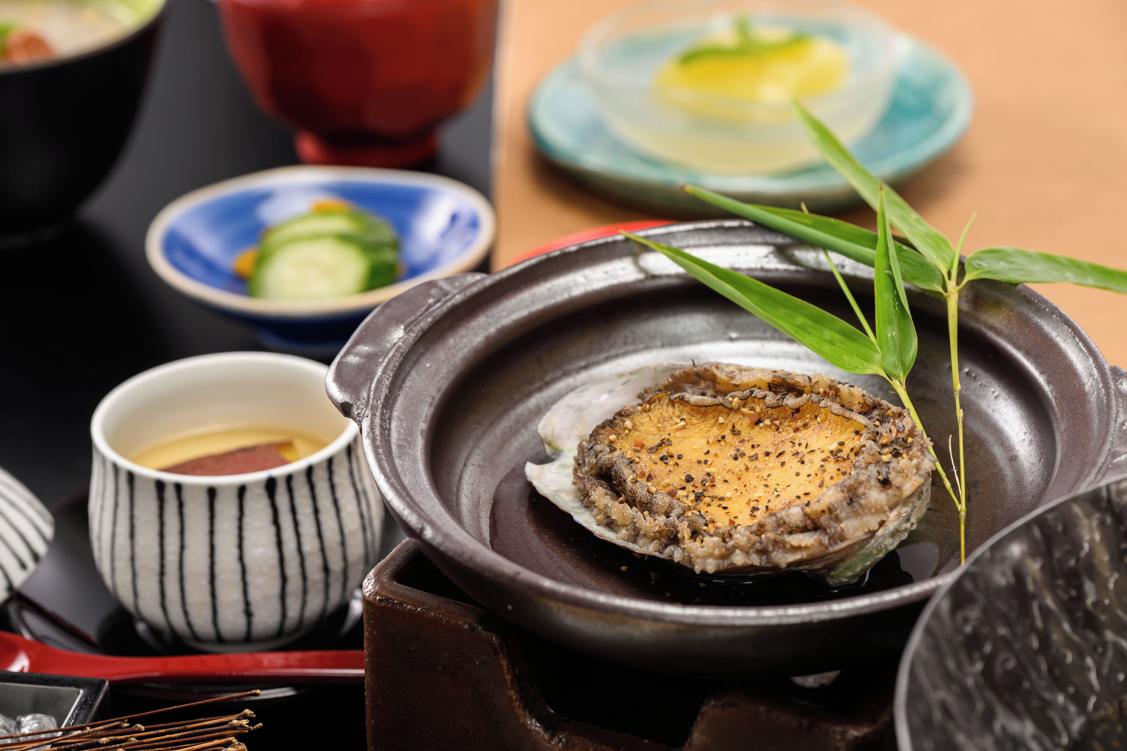 Una comida tradicional japonesa con un olla caliente, cuencos pequeños y palillos.
