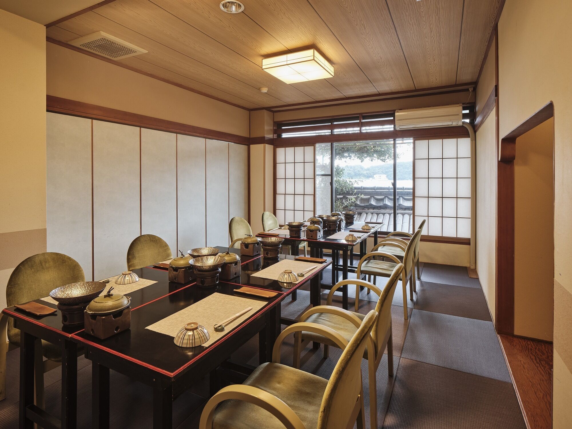 Uma sala de reuniões tradicional em estilo japonês, com tatames, mesas baixas e biombos shoji.
