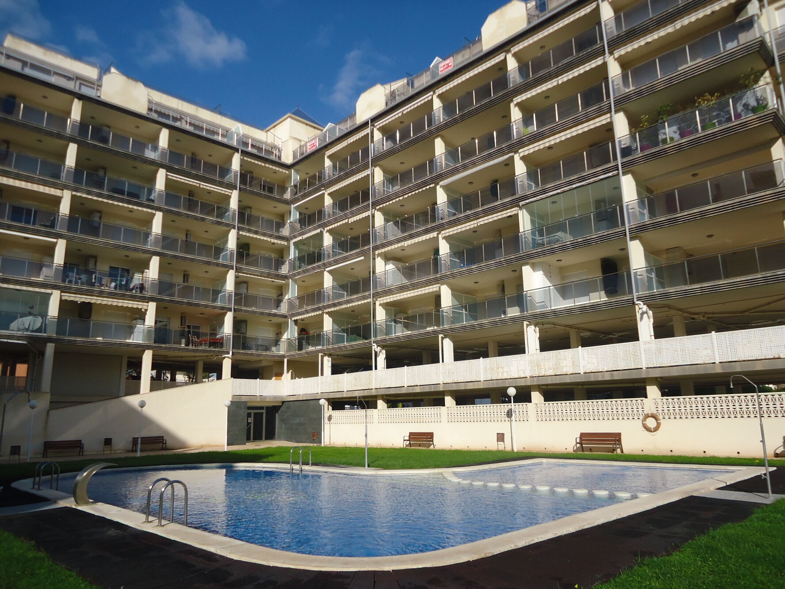 A multi-story building with a swimming pool in the foreground.