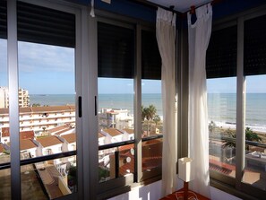 A balcony with large windows overlooking a beach and residential area. - P. Maritimo 40 Frontal LEK (Peñiscola)