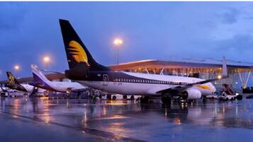 An airport terminal with a large airplane parked in the foreground.