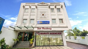 Un immeuble portant une enseigne indiquant « fabHOTELS » et « Sam Residency ».