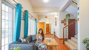 Una sala de estar con un sofá, una mesa de centro y una escalera que sube a un piso superior.