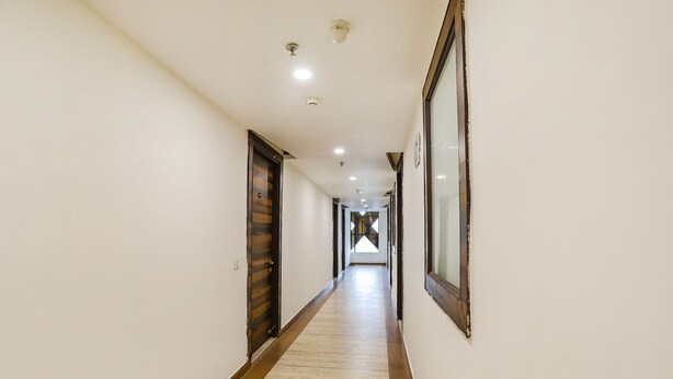 Un long couloir étroit, doté d’un plancher en bois et de murs blancs.