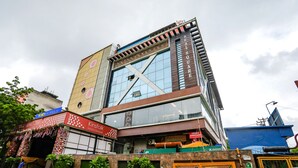 Un immeuble à plusieurs étages doté d’une façade en verre, d’une enseigne indiquant « Hôtel Kinsfolk et boutique » et d’une autre enseigne indiquant « Meilleurs hôtels ».