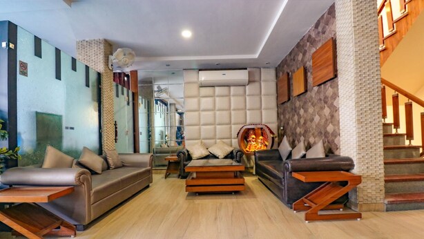 A modern living room with a sofa, coffee table, and a fireplace. - Fabhotel Narula (Dehradun)