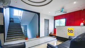 A hotel reception area with a staircase, reception desk, and seating area. - Fabhotel Fortune Begumpet (Hyderabad)
