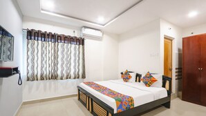 A bedroom with a bed, curtains, an air conditioner, a wardrobe, and a telephone. - Fabhotel Fortune Begumpet (Hyderabad)