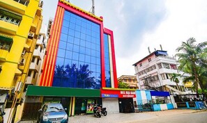 Un immeuble à plusieurs étages doté d’une façade en verre remarquable et d’une couleur extérieure rouge et jaune.