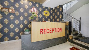 Ein Empfangsbereich mit einem 'RECEPTION'-Schild, dem 'fab hotels'-Logo, einem 'No Smoking'-Schild und einer Treppe mit einer 'WELCOME'-Fußmatte.