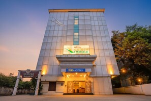 Un hôtel moderne, reconnaissable à son enseigne bien visible portant le nom « Hotel Golden Emerald ».