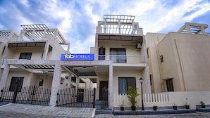 Un hotel moderno con un cartel que dice "Tab Hotels". Presenta una estructura de varios pisos con balcones y una entrada cubierta.