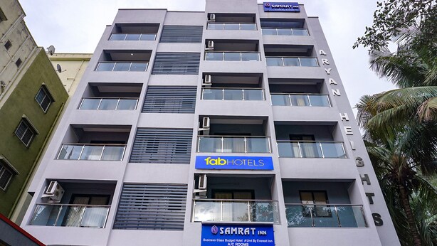 A multi-story hotel with a modern facade, featuring balconies, air conditioning units, and signage for 'Fab Hotels' and 'Samrat Inn'. - Fabhotel Everest Inn (Pune)