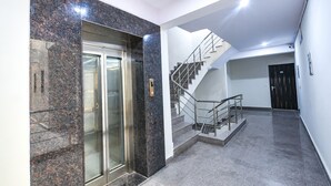 Een modern interieur met een marmeren lift, een trap en een eenvoudige muur.