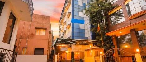 Un hotel con entrada cubierta, camino de acceso cerrado y una combinación de arquitectura moderna y tradicional.