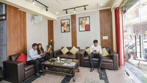 A modern hotel lobby with leather sofas, a coffee table, and artwork on the walls. - Fabhotel Ishtara Auberge (New Delhi)