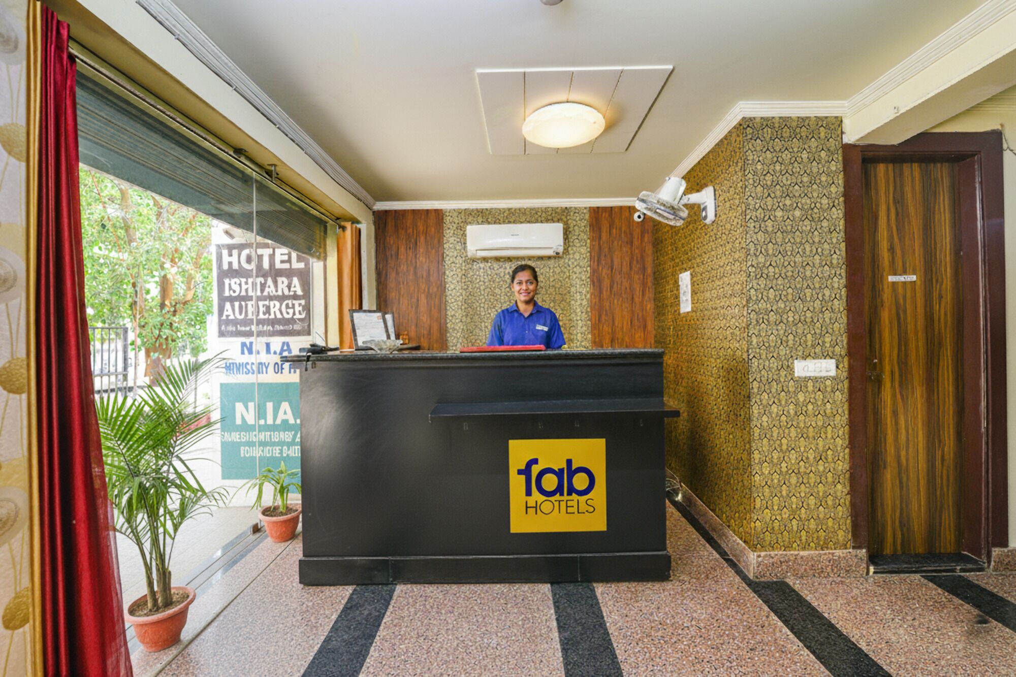 Un comptoir d’accueil d’hôtel avec une enseigne indiquant « fab hotels ».