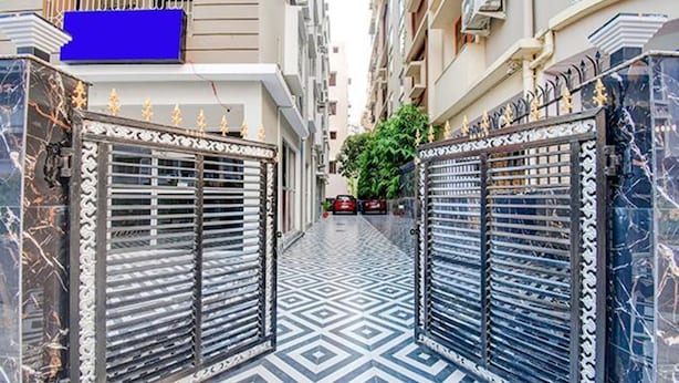 A narrow alleyway with ornate metal gates and patterned floor tiles. - FabHotel Trishiv - Newtown Kolkata (Barasat)