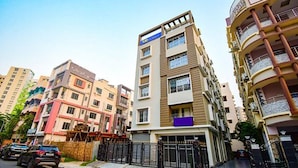 A multi-story residential building with a flat facade, balconies, and a gated entrance. - FabHotel Trishiv - Newtown Kolkata (Barasat)