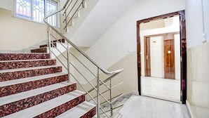 A staircase with metal railings and a door leading to another room. - FabHotel Trishiv - Newtown Kolkata (Barasat)