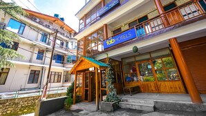 A multi-story hotel with balconies, a wooden entrance, and large windows. - Fabhotel Hadimba Heights (Manali)
