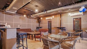 Un ristorante con sedie in vimini, tavoli e un'area bar.