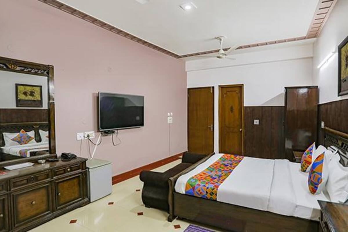 Quarto com cama, televisão, penteadeira e guarda-roupa.