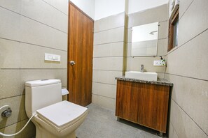 A small bathroom with a toilet, sink, and mirror.