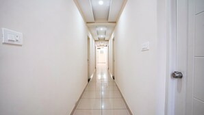 Un couloir propre et bien éclairé, avec un sol carrelé et des murs blancs.