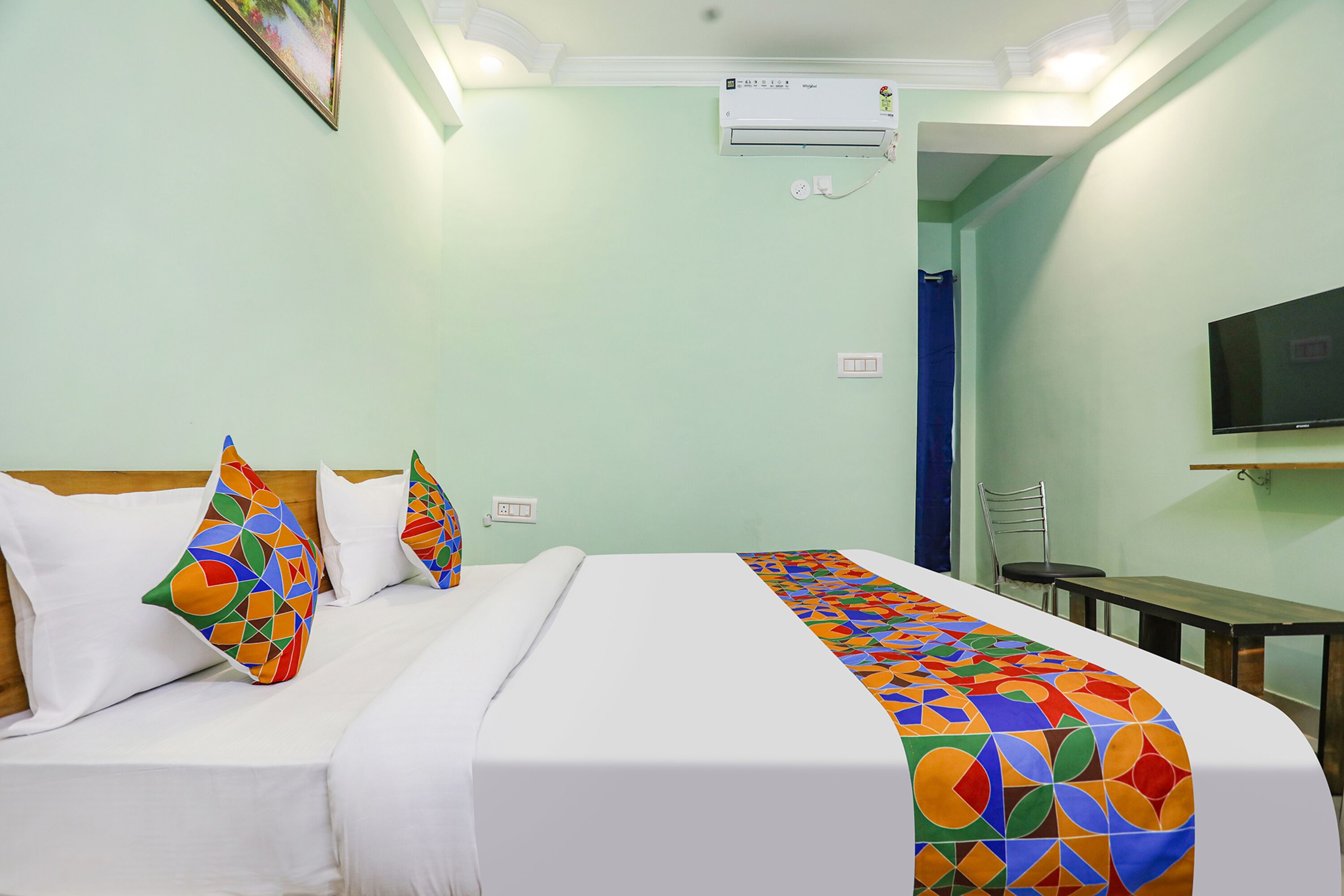 A hotel room with a bed, a TV, and a window.