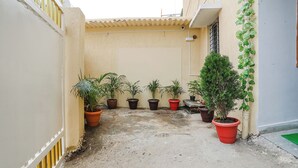 A narrow courtyard with potted plants and a small tree. - Fabhotel Sonnet Inns (Ranchi)
