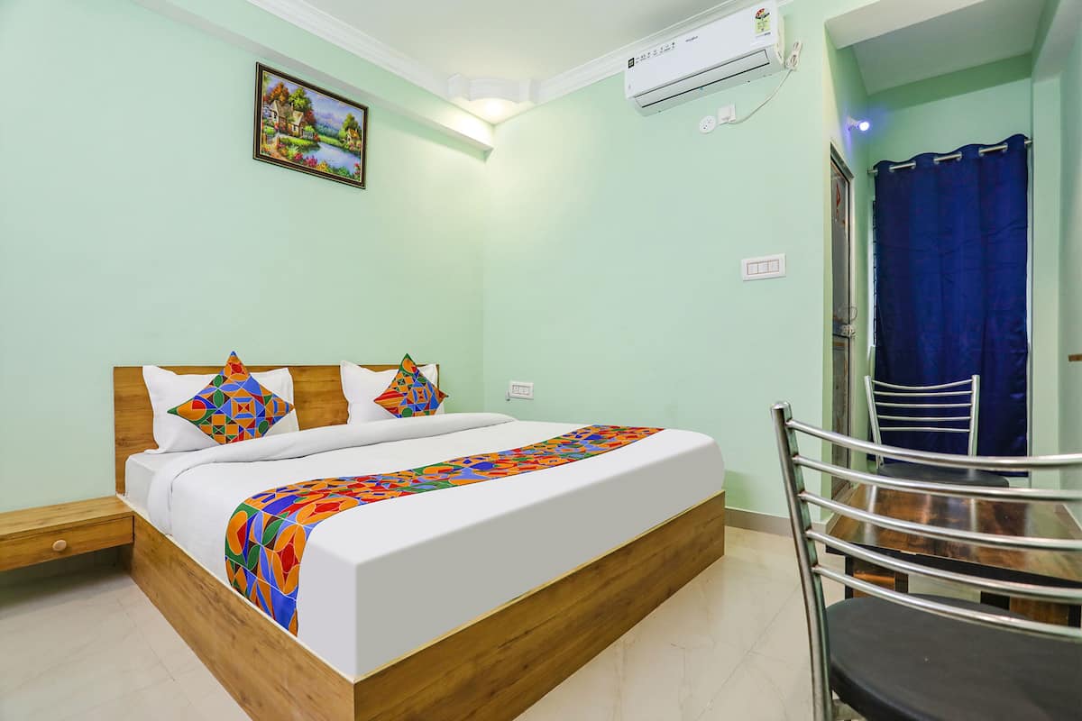 Una cama bien hecha con un edredón colorido, un cabecero de madera y un cuadro en la pared.