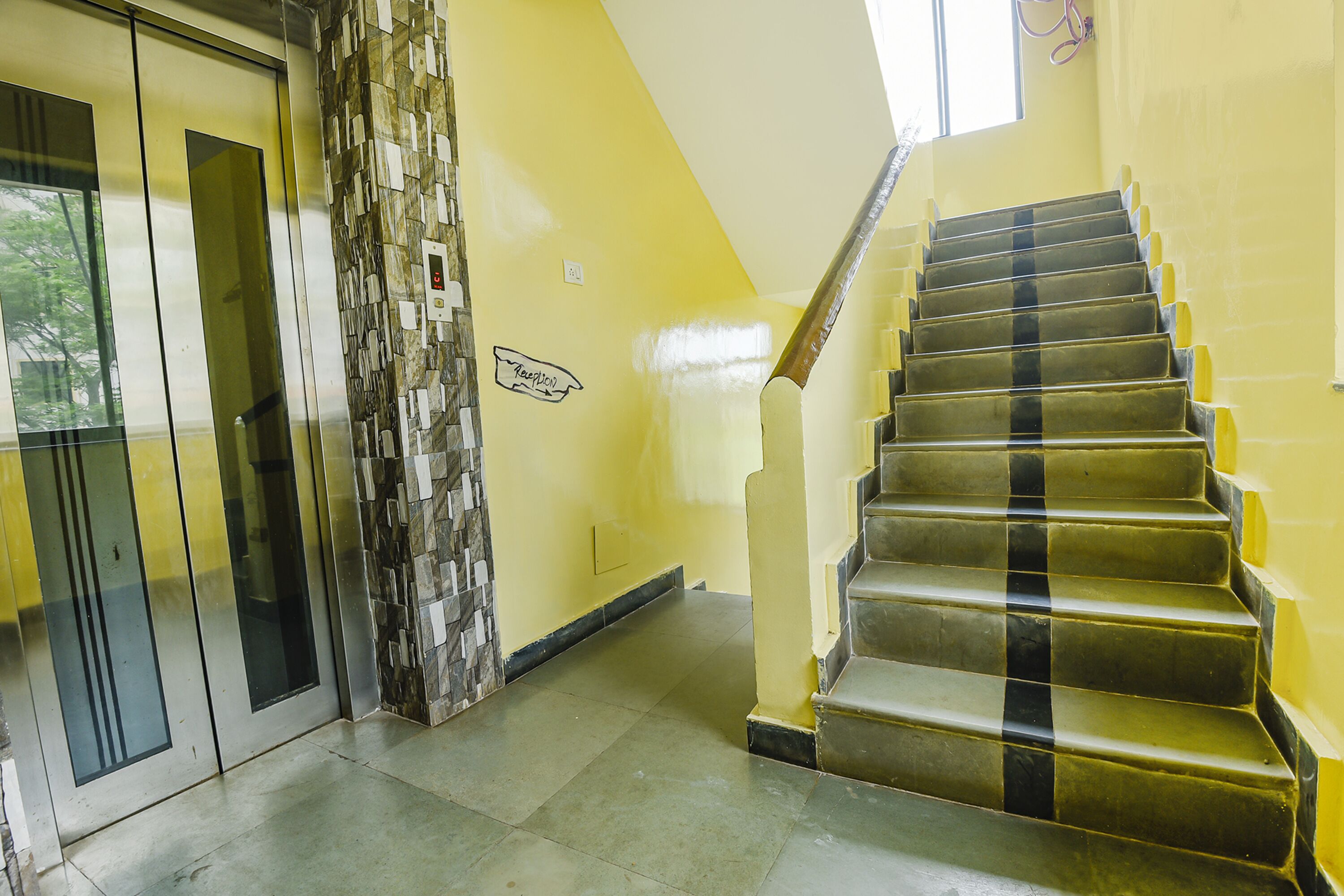 A staircase with a handrail, a wall with a sign, and a door with a glass panel.