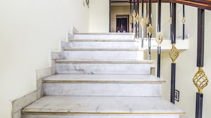 A marble staircase with black and gold railings leading to an upper level. - Fabhotel Four Boutique (Jaipur)