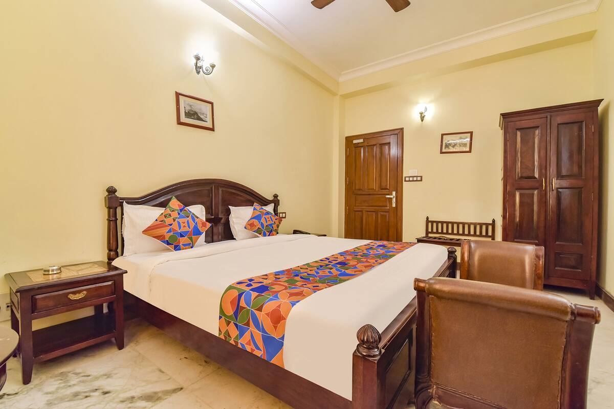 A bedroom with a wooden bed, a nightstand, a chair, and a wardrobe.