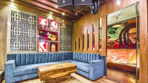 A modern lounge area with a blue sofa, wooden coffee table, and decorative wall panels. - Fabhotel Four Boutique (Jaipur)