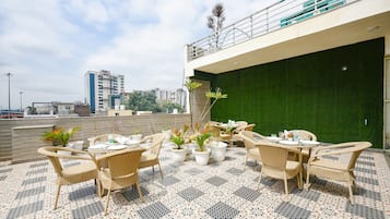 An outdoor patio area with wicker furniture and potted plants.