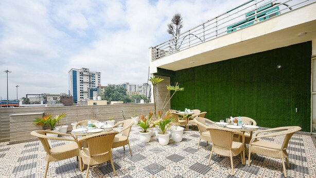 An outdoor patio area with wicker furniture and potted plants.