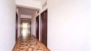 Un pasillo largo y estrecho con suelo estampado y puertas de madera a ambos lados.