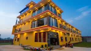 Un hotel a più piani con facciata gialla, ampie finestre e un cartello con la scritta "Radhotel".
